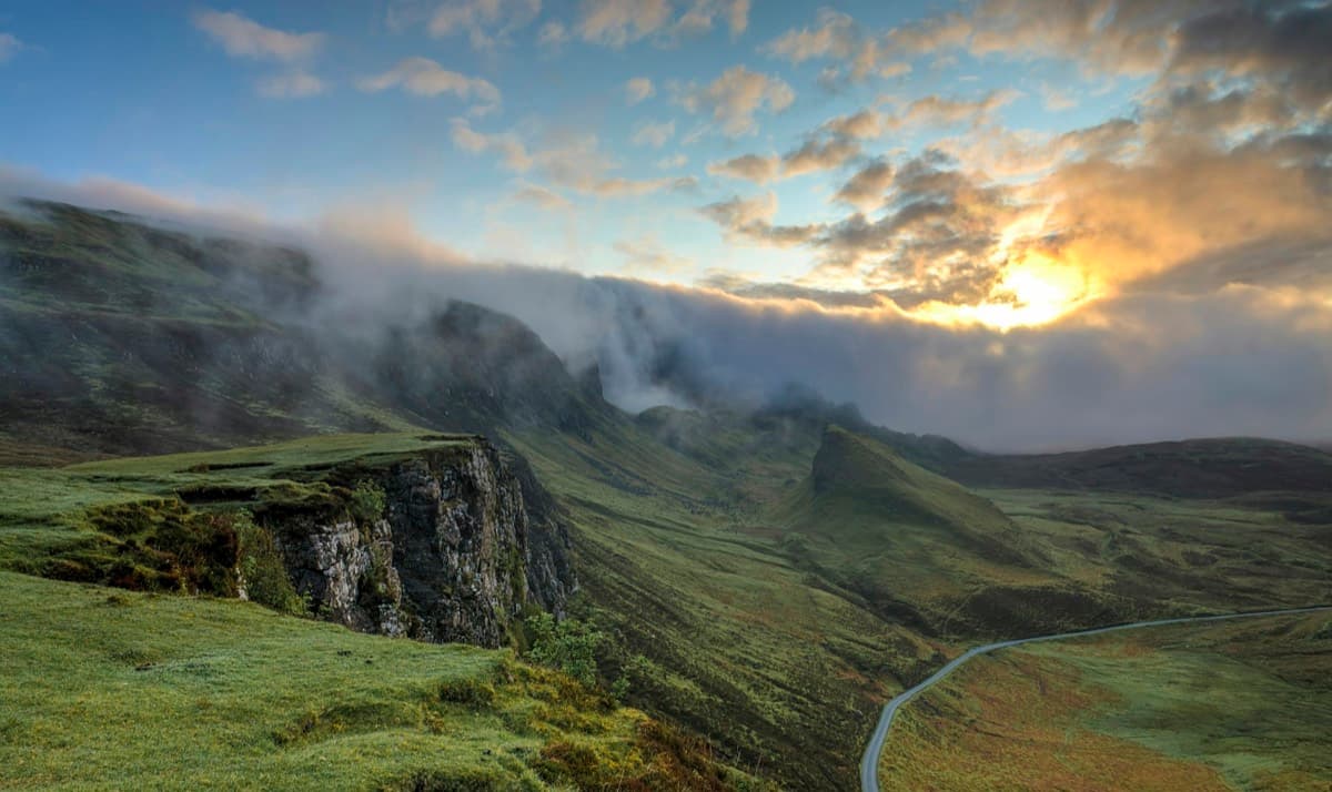 Rolling green hills under a sunrise sky